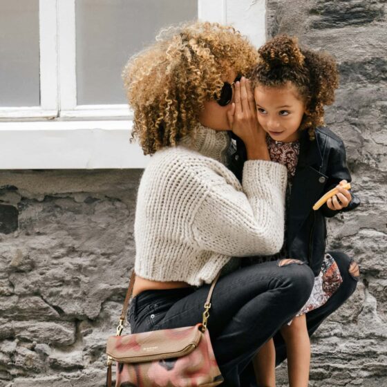 Woman whispering into child's ear